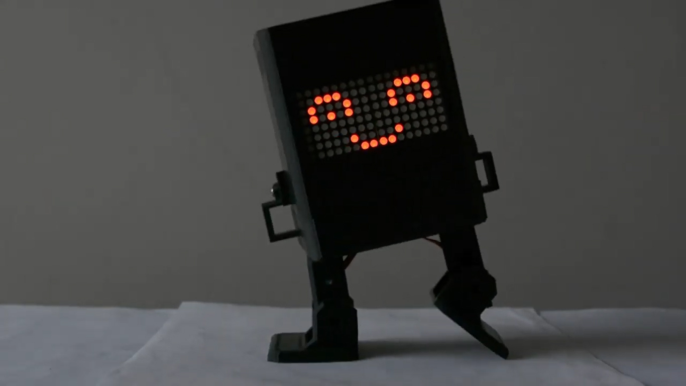 A small black robot dancing with a digital smile on its face.