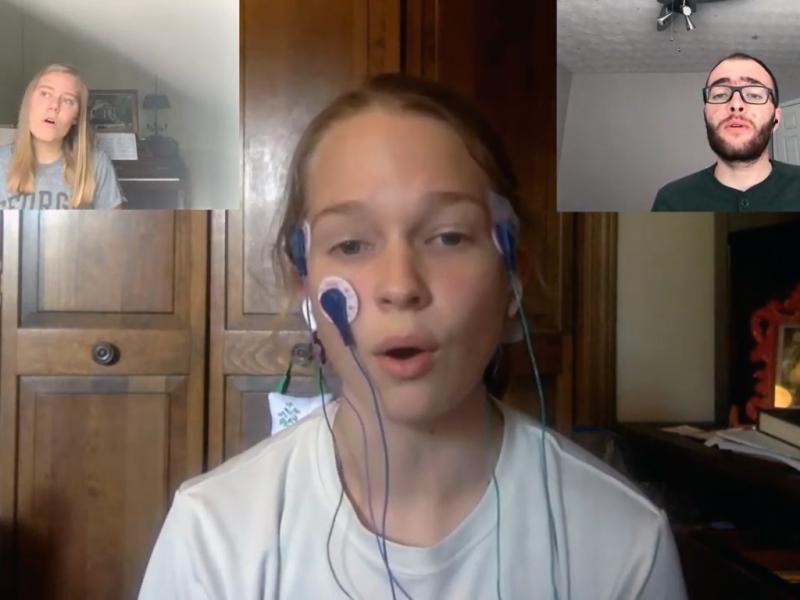 Three students singing on a teleconference call while demonstrating their project.
