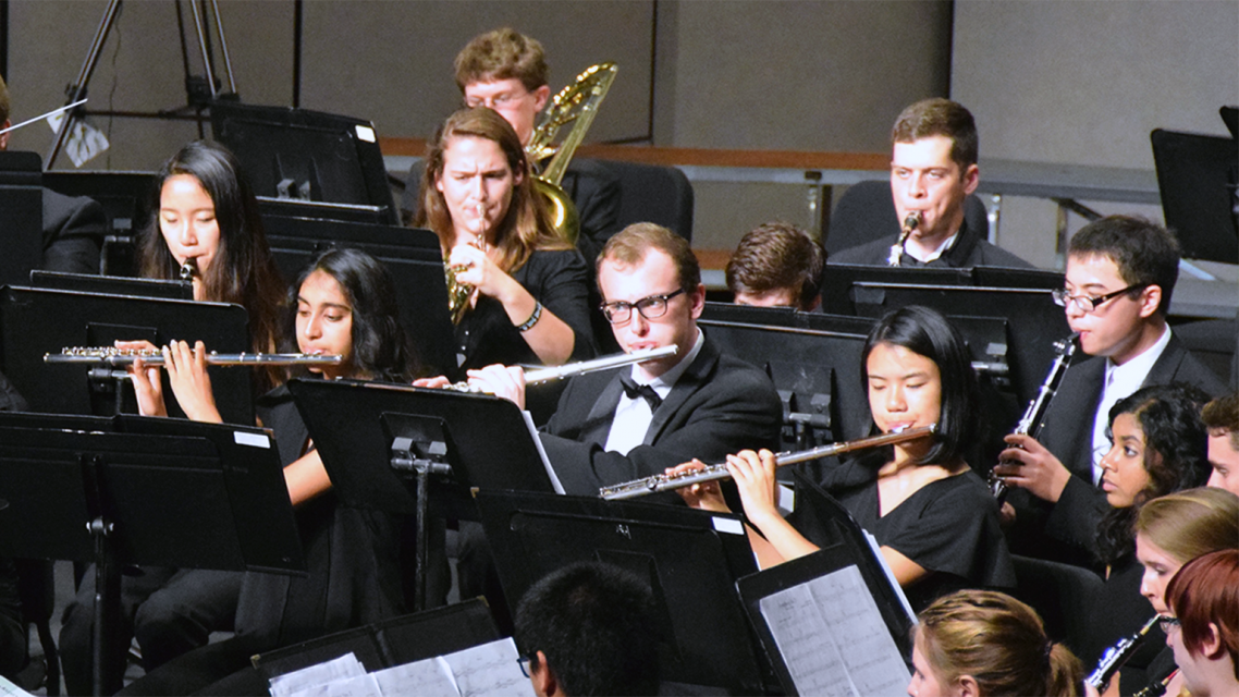 Concert band flute section performs on stage