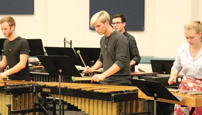 Percussion ensemble members rehearse on marimbas
