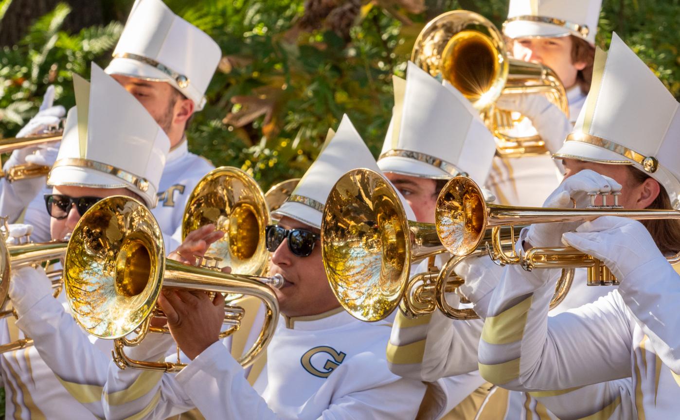Trumpet section of marching band playing outside