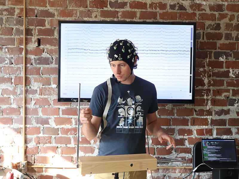 Student plays the Theremin while wearing an EEG cap