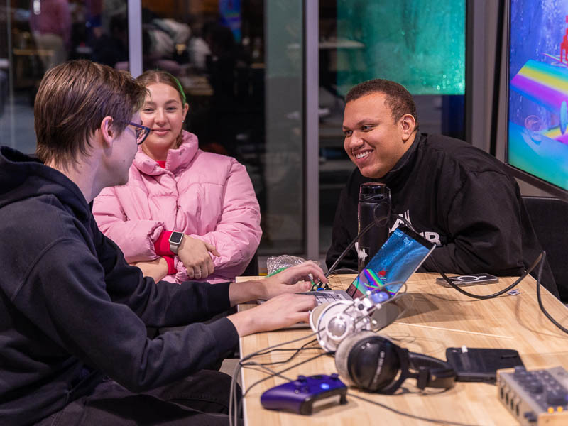 Students smiling as they interact with one of the projects