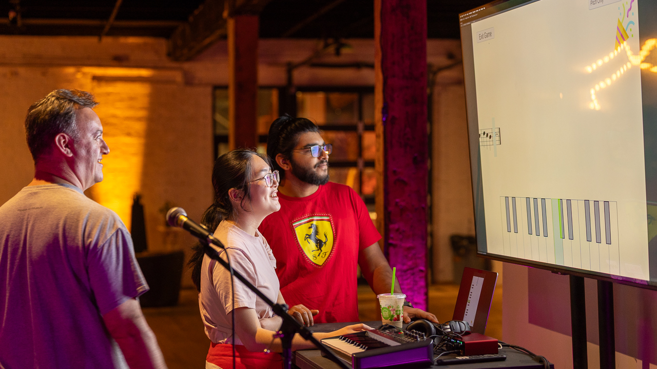 People looking at a projection screen showing Pitch Pal, a musical pitch trainer